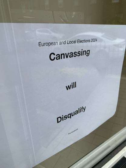 Sign on door window saying Canvassing Will Disqualify in reference to the 2024 Irish Local and EU elections.