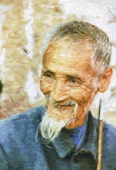 Local old Yi man smoking a pipe in a small village in the mountains in Yunnan, China. Painterly
