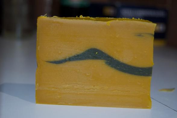 Un savon rouge-orangé avec un pattern de colline noir au centre