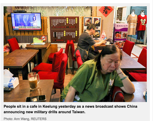 Two people sitting in a cafe in Keelung nonchalantly ignore a TV broadcasting news about China's military drills around Taiwan.