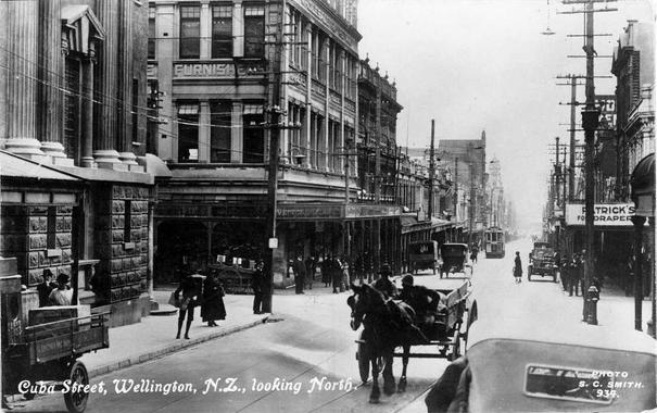 Black-and-white photo: Cuba Street, Wellington, looking north from Vivian Street corner. ca. 1924. Photographer, Charles Sydney Smith. Description: Cuba Street, Wellington, looking north, showing the National Bank of New Zealand, Te Aro Branch on the corner Vivian and Cuba Streets, left hand side. There are pedestrians on both footpaths (BrE pavements, AmE sidewalks) and a few motor cars, a horse-drawn vehicle (foreground) and a tram (background) on the street. Citation: Ref: 1/2-029894-F. Alexander Turnbull Library, Wellington, New Zealand. https://natlib.govt.nz/records/23179979