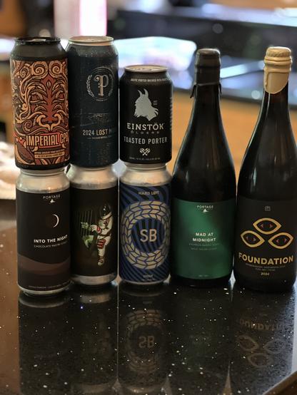 Cans and bottles of beer from the vendors mentioned in the post. Four pint cans are stacked two-high on the left, a 12 ounce can is atop another pint can in the middle, and two 750ml bottles are to the right.