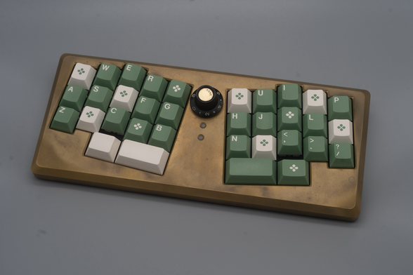 Brass ergonomic keyboard with green and white keycaps