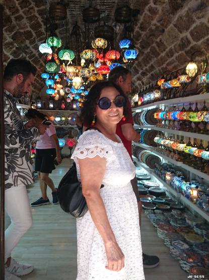 Farbfoto im Gewölbe eines Kunsthandwerkladens in Kotor, Montenegro. Im Regal rechts und an der Decke hängen viele bunte Laternen, wie sie eigentlich eher für die Türkeit typisch sind. Im Foto zu sehen sind auch vier Besucher des Geschäfts.