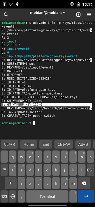 A terminal window on a mobile phone running phosh showing the output of "udevadm info".