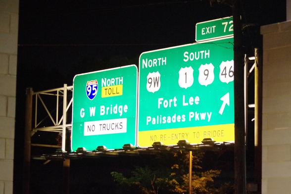 Highway signs in front of my hotel (which is at the western end of George Washington Bridge), illuminated at night.