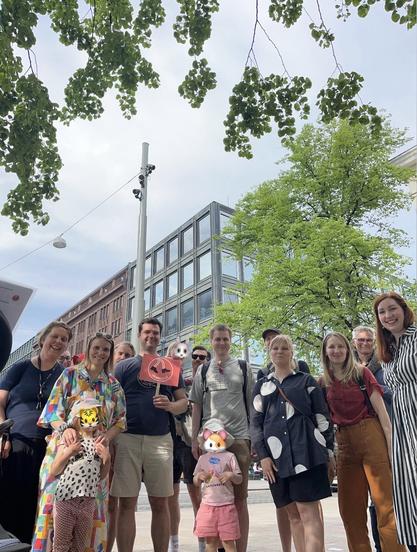 Valokuva seurueesta. Noin 15 henkilön ryhmä, jossa tunnistettavia henkilöitä ovat hallituksen jäsenet vasemmalta oikealle Anni Lyytikäinen, Sami Määttä, David Pemberton ja Hanna Hannus. 3 lasta, joiden kasvot on peitetty eläinhymiöillä.