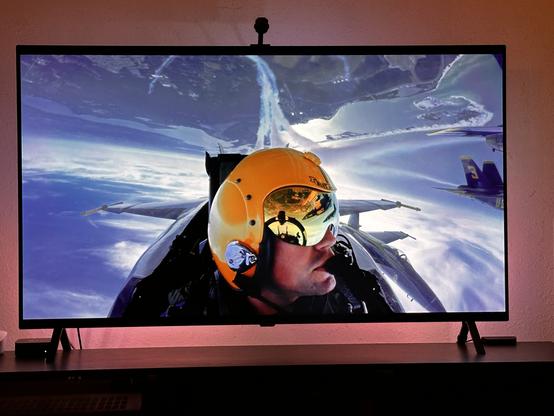 TV showing Blue Angels F-18 cockpit view facing aviator inverted.