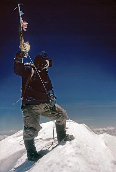 Sherpa Tenzing Norgay holding an ice-axe and small flag atop Mount Everest, taken by Sir Edmund Hillary, as the pair became the first humans to reach the top of the highest mountain on 29th May, 1953