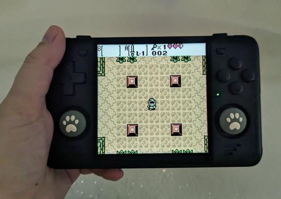 Powkiddy RGB30 retro handheld showing The Legend of Zelda Oracle of Seasons being played on it. There's bubbles in the bathtub.