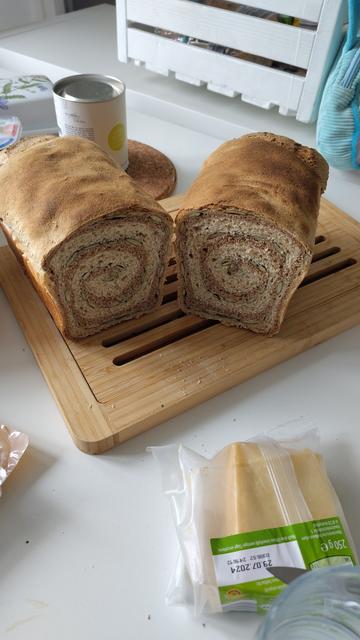 Aufgeschnittenes Brot. Es ist ein Wirbel aus Vollkornteig und Sonnenblumenkernen mit eingearbeitet.