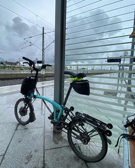 Klapprad am nassen Bahnsteig, dramatische Wolken