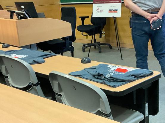 Front table with two sizes of T shirts left small and ?