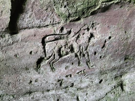 An image of a four legged animal carved into rock.
