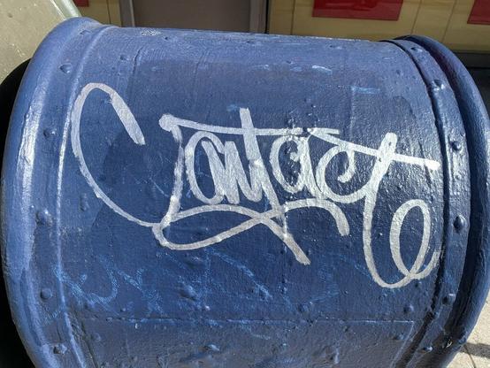 A blue USPS mail box with "Contact" written in a silver metallic ink. The graffiti is written crisp and ornate.