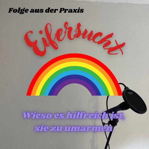 Auf dem Regenbogen ist der Schriftzug Eifersucht zu lesen. Im hellen Hintergrund lässt sich ein Mikrofon in der rechten unteren Ecke erkennen.