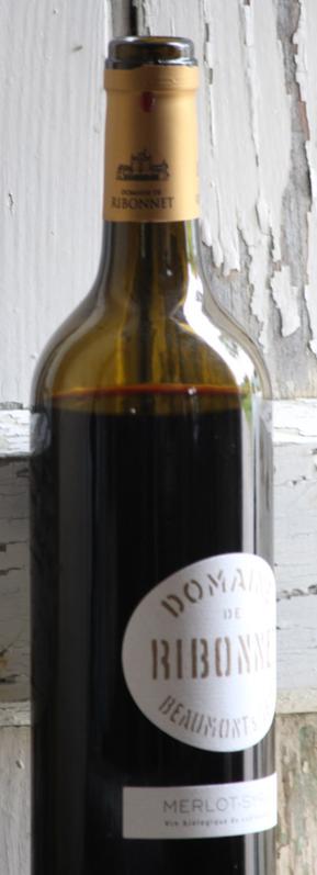 image d'une bouteille de vin rouge devant un volet en mauvais état.