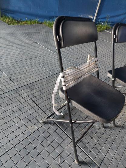 A back rest for a folding chair, made out of roof rack webbing and some cat-3 cable.