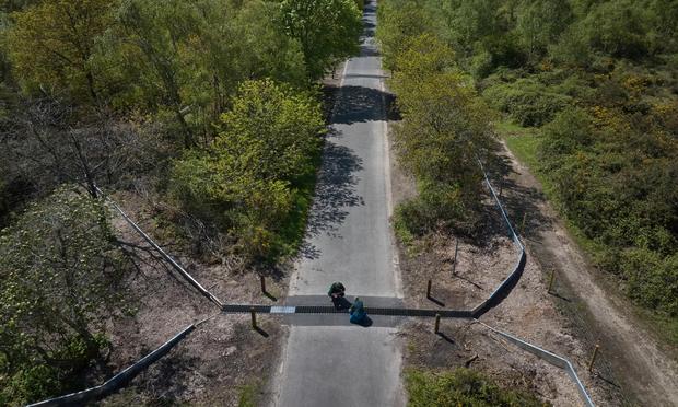 aerial photo of a small wildlife crossing under a narow road