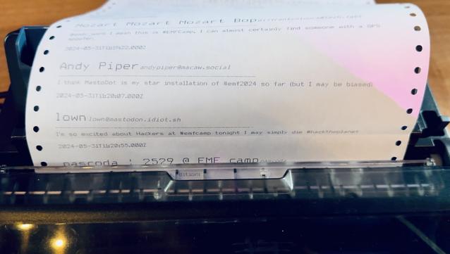 A dot matrix printer with a roll of paper showing a printed Mastodon post from the author
