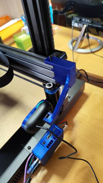 A modified Logitch C270 webcam mounted to the horizontal bar of a 3d printer (an Artillery Sidewinder X2) with a custom printed arm.
