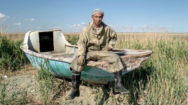 photo - Nafisa Bayniyazova sitting on an abandoned boat in an area of water loss, Muynak, northwestern Uzbekistan