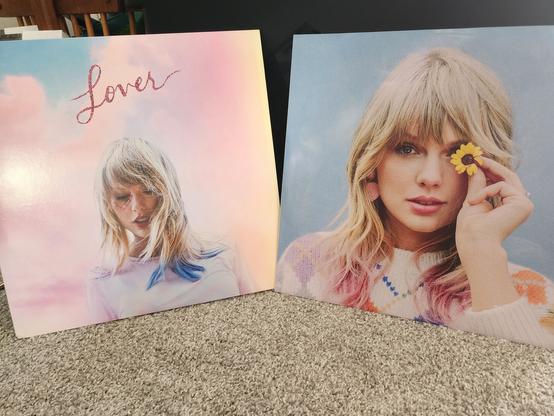 cover of Taylor Swift's Lover album on the left, which features Taylor Swift with the word Lover above her, on a pastel background

on the right, Taylor Swift is holding a yellow flower up to her right eye while looking at the camera