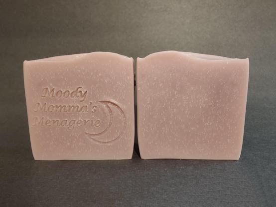 Two light purple colored soaps sitting side by side. The bar on the left is stamped with my branding "Moody Momma's Menagerie" and a crescent moon.