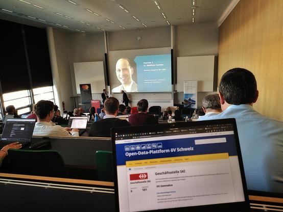 A laptop showing Open Data Platform ÖV Schweiz in front of an auditorium full of people watching a presentation