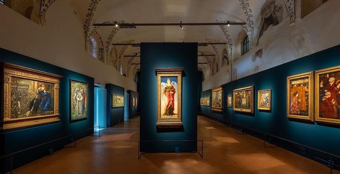 The spacious Burne-Jones room with its deep blue walls hung with a variety of his paintings.