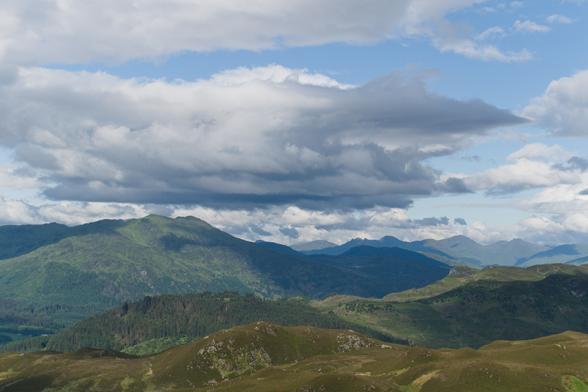 green mountains in light and shadow with clouds