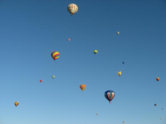A picture of numerous hot air balloons flying in the clear blue sky at the Albuquerque International Balloon Fiesta.