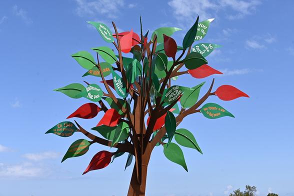 Der Baum der Freiheit hat rote und grüne Blätter mit Texten darauf. Auf einem Blatt steht: weder Hass noch Vergessen.