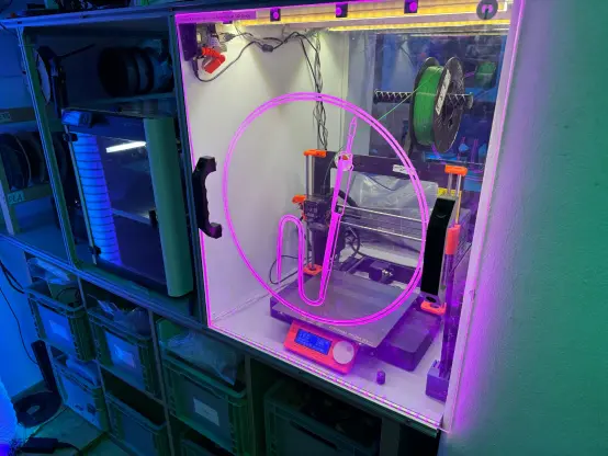 A prusa 3d Printer in an enclosure engraved with the havkerspaces logo