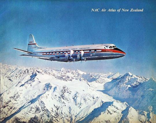 Four engine prop plane is flying high above snowy Mountains