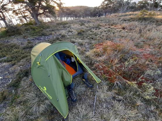 La tente se dresse sur l'île inhospitalière de Navarino au Chili. Le soleil réchauffe le sol que le vent refroidit.
