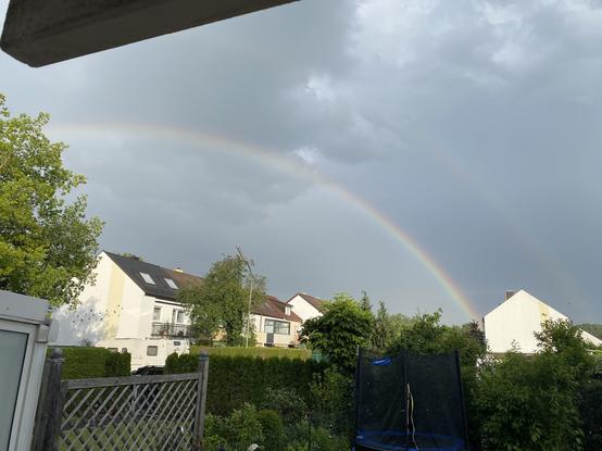 Regenbogen über Reihenhaus-Siedlung mit Hecken