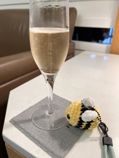 A little knitted eBee (the mascot for eBPF) and a glass of champagne