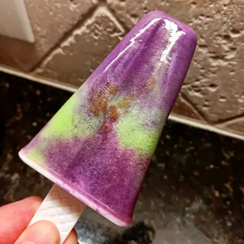 frozen semi triangular shaped popscicle with green and purple.