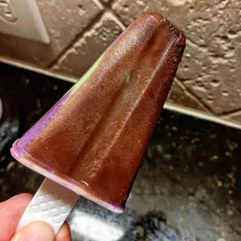 frozen semi triangular shaped popscicle with a warm brown coating.