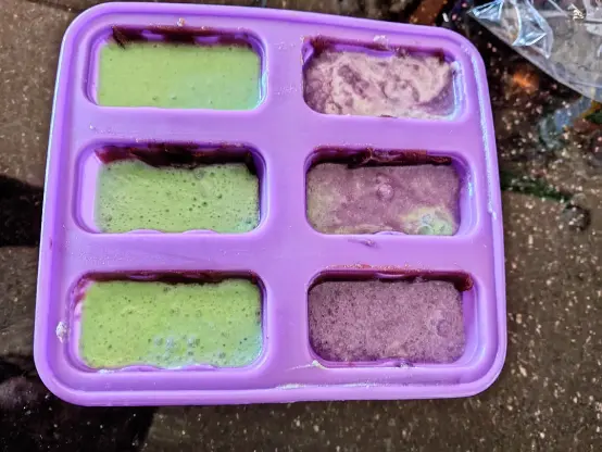 purple popscicle mold filled with 1/2 green and 1/2 purple mixtures.