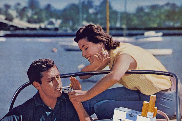 1964 Couple enjoying a moment of relaxation

The image features a man and a woman in what appears to be a casual outdoor setting.
They are both seated, with the man on a bench and the woman standing behind him.
The man is engaged in smoking a cigarette while holding an ashtray, possibly indicating that he is the one being attended by the woman.
There's no text visible in the image.