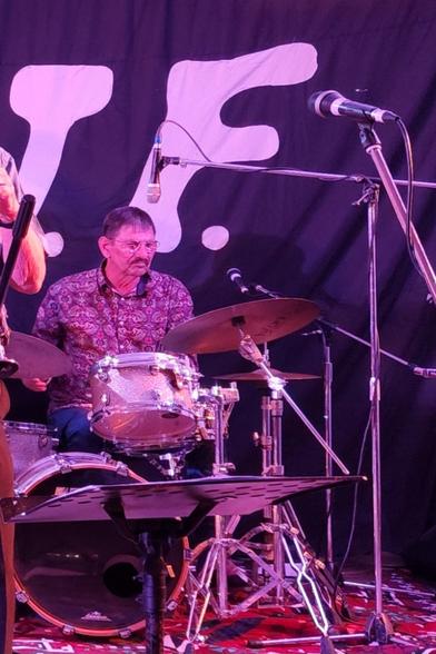 Old bloke with purple shirt, on drums. Cool!