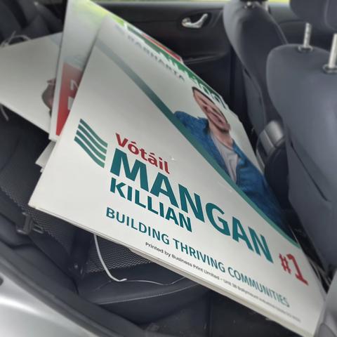 A photo of lots of taken-down posters in a stack in a car.