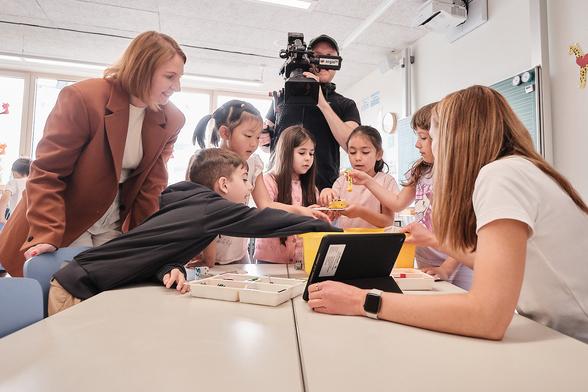 Grundschülerinnen und Grundschüler, Staatssekretärin Boser und ein Kameramann. Foto: Michael Damböck