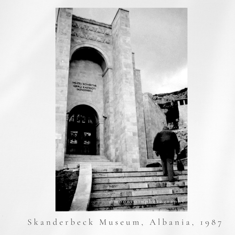 High arched door way of a museum, a person is walking up steps towards the door. The photo is in black and white. Skanderbeg Museum, Kruje, Albania, 1987. 35mm image
