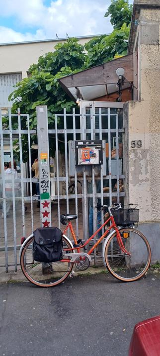 Un vélo devant la grille d'entrée de L'AÉRI 59, rue Étienne Marcel à Montreuil