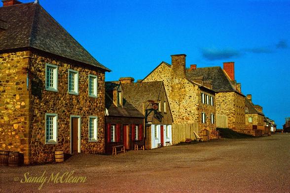 Historic stone buildings on a street in the restored fortress at Louisbourg, NS.