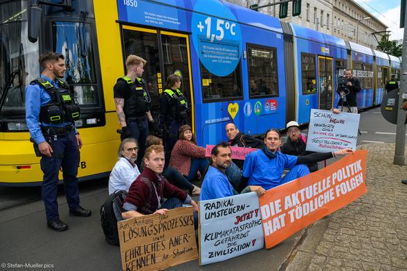 Der fast 100-tägige Hungerstreik von „Hungern, bis Ihr ehrlich seid“ wurde mit einer Straßenblockade beendet. Im Hintergrund die Klimatram von Scientists for Future, Berlin 4 Future und der Stiftung Gesunde Erde Gesunde Menschen, Invalidenpark, Berlin, 13.06.2024