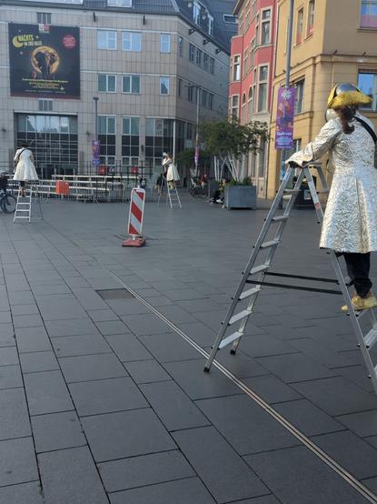 vor der Ehrentribüne drei lilliput auf ihren klappleitern verkünden die Ankunft von Gulliver